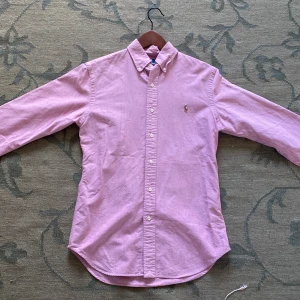 Rosa skjorta från Polo Ralph Lauren - Säljer en rosa långärmad skjorta från Polo Ralph Lauren i slim fit, pris kan diskuteras. Nypris 1750kr