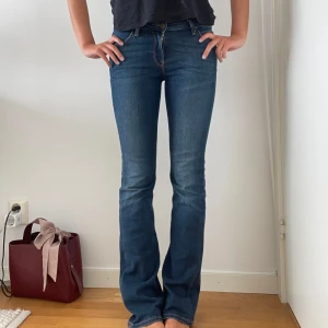 Mörkblå bootcut jeans från Lee - Snygga mörkblå jeans från Lee med klassisk bootcut-passform. Jeansen är normal i midjan och är tillverkade i stretchigt denim Perfekta till sneakers eller boots och funkar året runt. Har lite slitningar längst ner på benen. Jag är 172cm