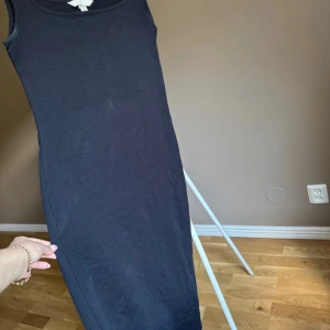 Svart ärmlös långklänning H&M - ❤️bilder från min Vinted ❤️En stilren svart långklänning från H&M i mjuk bomull. Klänningen är ärmlös med breda axelband och har en figurnära passform som ger en clean och enkel look. Perfekt att styla med sneakers eller boots för en chill vibe.