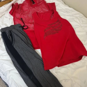 Grå mjukisbyxor, linne och en nätt tröja - Snygga grå mjukisbyxor med svarta meshpaneler längs benen som ger en sportig vibe. Byxorna har resår i midjan och är perfekta för chill eller träning. Materialet känns mjukt och bekvämt mot huden.