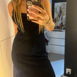 Mörkblå glittrig långklänning  - Supersnygg mörkblå långklänning från Be Smart med tunna axelband och glittriga detaljer. Klänningen har en draperad urringning och sitter figurnära upptill. Perfekt för dig som vill sticka ut med en elegant och trendig look. Jag hade denna på min bal i gymnasiet 🩷