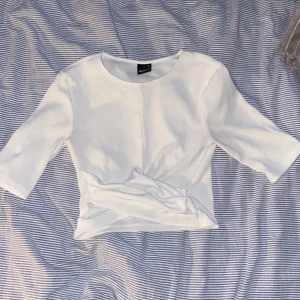 Vit topp med knytdetalj Gina Tricot - Säljer en vit T-shirt typ från Gina, väldigt basic men väldigt snygg.