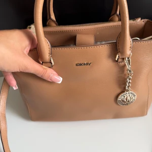 Beige handväska från DKNY i skinn - Nästan helt oanvänd DKNY väska.  Finns i Gbg men kan fraktas!