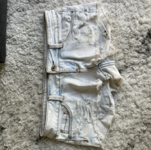 Lowwaist mini jeansshorts med rivna detaljer - Snygga vita jeansshorts i strl 38, midja:42. Kommer fler liknande jeansshorts/kjolar så följ!!