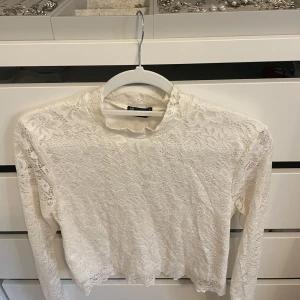 Vit spetsblus - Superfin vit spetsblus med långa ärmar och helt täckt av blommig spets. Står storlek L men passar XS-L.