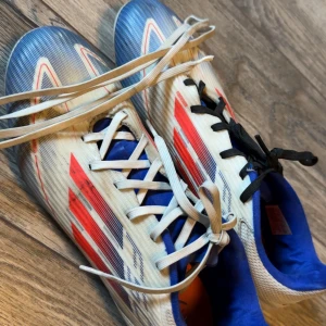 F50 | Adidas fotbollsskor i vitt, blått och rött - Behöver pengar för nya skor så säljer dessa F50 , ingen e fel med dessa. Skriv till mig så kan vi diskutera priset 👍