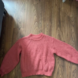 Rosa stickad tröja från Gina Tricot - Supermysig stickad tröja i en härlig rosa färg från Gina Tricot. Tröjan har en ribbad hög hals, långärmade ärmar och en loose fit. Perfekt för lager på lager under kyliga dagar. Snyggt strukturerad stickning som ger en trendig vibe.