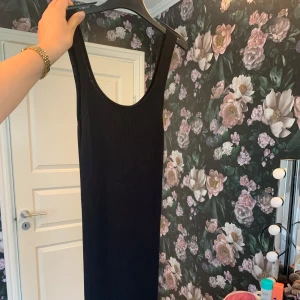 Svart ribbad långklänning Lindex - Svart ribbad långklänning från Lindex i storlek S. Klänningen är ärmlös med rundad urringning och har en tight passform som framhäver siluetten. 