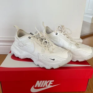 Nike TC 7900 vita sneakers strl 38.5 - Nike TC 7900 sneakers i helvitt med chunky sula och snygga detaljer. Skorna har snörning, mesh och skinnpaneler samt små svarta loggor. Perfekta för dig som gillar sportig och modern stil. Säljes i originalkartong. Fåtal användning i gym. Nypris 1399kr