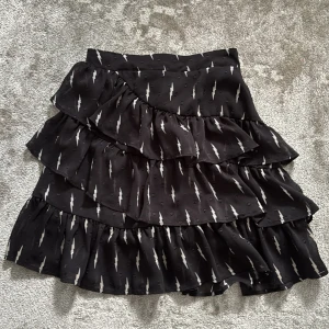 Svart volangkjol från Sofie Schnoor - Supersnygg svart kortkjol från Sofie Schnoor med coolt blixtmönster i vitt. Skriv vid frågor🩷