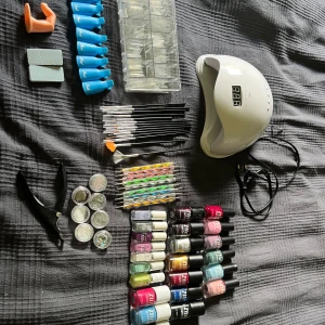 Nagelkit  - Nagel kit med allt som behövs för nybörjare! I kittet finns det: 13 st ztiz nagellack + 3 gel lack 7 st depend nagellack 1 st övningsfinger 2 st filar 10 st nagelklämmor 100 st tippar 1 st nagellampa 14 st penslar 10 st dotting tools  7 st olika dekorationsstenar 1 st lösnagelklippare nagellacken är öppnade men inget lack är mindre än halvfullt.
