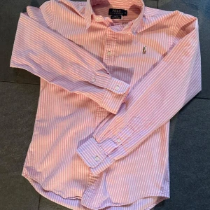 Rosa randig skjorta Polo Ralph Lauren - Säljer en rosa och vit randig skjorta från Polo Ralph Lauren i slim fit. Passar 170. Skriv om funderingar eller bilder!
