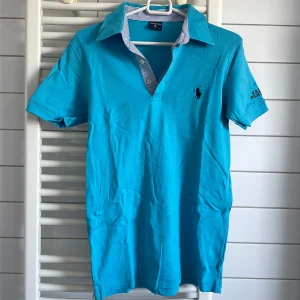 Turkos polo t-shirt från Polo Ralph Lauren - Turkos polo t-shirt från Polo Ralph Lauren med klassisk krage och två knappar. Liten i storleken, mer som M och S.