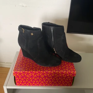 TORY BURCH klackar  - Väldigt eleganta och stiliga Tory Burch klackar i hel svart med guldig dragkedja och fina detaljer  som har bara andvänts få gånger. Skorna kommer med en box och påse!