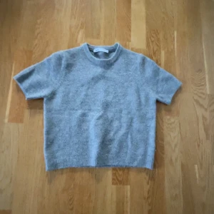 Grå stickad kortärmad tröja från Zara - Stickad kortärmad tröja från Zara säljer pågrund av att den inte används använd 1-2 gånger💞