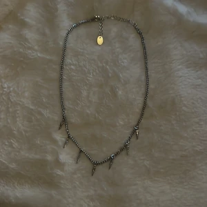 Silvrigt halsband med blixtar  - Ett silvrigt halsband med blixtberlocker. Aldrig använt och inget rost. Skriv om ni vill ha tydligare bilder