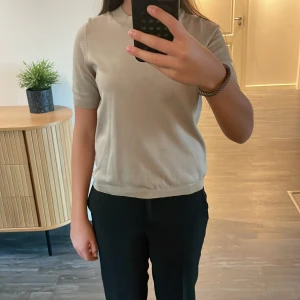 Beige t-shirt från Lindex XS - En stilren beige t-shirt från Lindex i storlek XS. T-shirten har korta ärmar, rund halsringning och är tillverkad i ett mjukt, stickat material. 