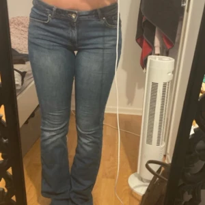 Blå bootcut jeans low rise - Säljer ett par klassiska blå jeans med bootcut-modell och low rise. Jeansen har fem fickor, dragkedja och knapp framtill. Snygg passform som sitter tajt över låren och släpper ut vid vaden. Perfekta till sneakers eller boots.