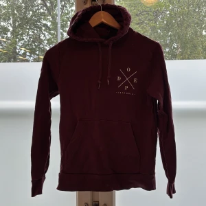 Dope hoodie jacka  - Dope hoodie vinröd lite urtvättad i förgen men helt ok skick, inga hål eller sliten. Se närbild på Dopetrycket som har tappat vit färg