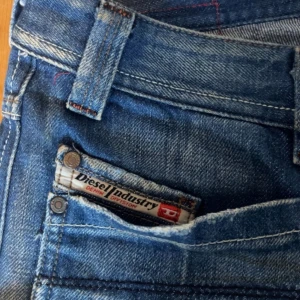 Diesel jeans - Säljer ett par jättesnygga blå jeans från Diesel med snygga slitningar och raka ben. Midjemått: ca 39cm. Innerbenslängd: 82cm!