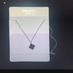 Silverhalsband med fyrklöver från Crystal - Stilrent halsband i silverfärg från Crystal Jewelry med en söt fyrklöverformad berlock. Kedjan är tunn och elegant, perfekt för att ge din outfit en extra touch. Berlocken har en glansig finish som fångar ljuset snyggt.