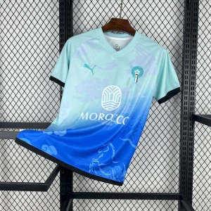Blå fotbollströja från Puma - Snygg fotbollströja från Puma i en gradient mellan ljusblå och mörkblå med subtila mönster och svart kant vid ärmslut. Tryck med 'MOROCCO' och emblem på bröstet. Perfekt för dig som gillar unik design och sportig stil.