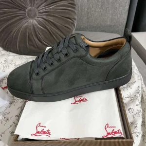 Mörkgrå sneakers från Christian Louboutin - Snygga mörkgrå sneakers från Christian Louboutin i mocka med klassisk röd sula och rund tå. Skorna har svarta snören och en stilren design som sticker ut med den ikoniska röda undersidan. Perfekta för dig som vill ha något exklusivt och trendigt.