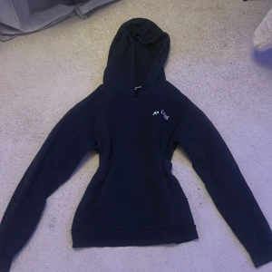 Marinblå hoodie - Marinblå hoodie från Gina Tricot med trycket 'Ma Chérie' och två hjärtan i silver på ryggen. Mjuk och skön med huva och långa ärmar. Perfekt för dig som gillar coola detaljer och vill sticka ut med ett snyggt print.