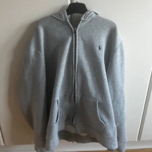 Polo Ralph lauren zip hoodie grå  - Snygg Ralph lauren zip hoodie i grå! Är i använt men fortfarande mycket bra skick, tröjan har inga defekter. Nypris: 1000kr, mitt pris: 400kr. Är i storlek XL 18-20, vilket ungefär motsvarar S i vuxenstorlek. Bara att höra av sig vid minsta intresse!😁