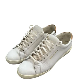 Vita sneakers från Saint Laurent - Snygga vita sneakers från Saint Laurent med leopardmönstrad detalj på hälen. Skorna har snörning och är tillverkade i skinn, vilket ger en lyxig känsla. Perfekta för en stilren look. Dom är storlek 41 1/2 men sitter som 42