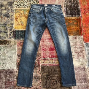 Replay Grover jeans straight fit - Snygga Replay Grover jeans i klassisk blå tvätt med coola slitningar och kontrastsömmar. Modellen har raka ben, fem fickor och läderpatch bak i midjan. Perfekt passform och stilren look, tillverkade i slitstarkt denim. Jeansens detaljer ger en modern vibe. Nyskick, 10/10. Pris 599. Hör av dig vid minsta fundering! 