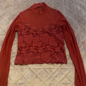 Röd spetsblus med polokrage , SHEIN  - Supersnygg röd långärmad blus med polokrage och blommig spets över hela framsidan. Toppen har en tight passform och transparenta ärmar, vilket ger en cool lager-på-lager-look. Perfekt för dig som vill sticka ut med detaljerad spets och trendig design.