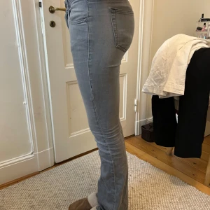 Grå jeans från Diesel - Snygga grå jeans från Diesel med bootcut passform och klassiska fem fickor. Jeansen har en är tillverkade i mjukt denimtyg med stretch för extra komfort. Nypris +1000 kr.