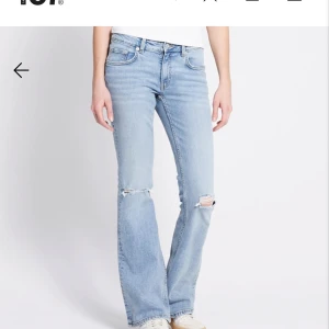 Lager 157 ljusblå bootcut jeans med hål i bena - KONTAKTA MIG GÄRNA INNAN KÖP. Säljer ett par ljusblå lager jeans med bootcut passform. Jeansen har slitna detaljer och hål vid knäna för en cool, avslappnad vibe. De är ”low boot” och använda en del i höstas förra året men inga defekter, nypris 400. ☺️