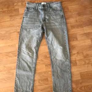 Jeans byxor från Jack and Jones - Fina byxor som har använts väl. Har storlek W28/ L30. Skick 6/10. Det syns en liten diskret fläck på baksidan, se bild 4. Priset är inte hugget i sten. Kom gärna med frågor!