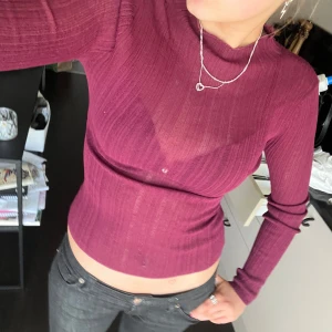 Vinröd ribbad croppad tröja från BikBok - Säljer en vinröd ribbad croppad tröja från BikBok. Tröjan har lång ärm och sitter tight mot kroppen. Perfekt att styla med jeans eller kjol för en snygg vardagslook.