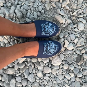 Espadrillos från Kenzo - Säljer ett par mörkblå espadrillos från Kenzo med ikoniskt tigerbroderi i ljusblått framtill. Skorna har flätad sula och är perfekta för sommaren. Inte använda så mycket då dom är lite för små för mig💙