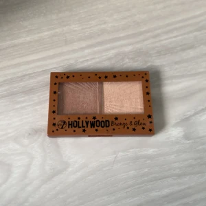 W7 Hollywood Bronze & Glow duo - En smidig duo-palett med bronzer och highlighter från W7. Paletten har ett brunt och ett champagnefärgat puder i rektangulär form, perfekt för att skapa lyster och värme i ansiktet. Kommer i en brun plastförpackning med spegel i locket.