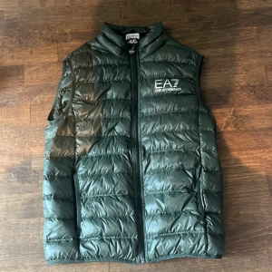 Grön ea7 väst - Säljer helt ny ea7 väst// storlek m// ingår påse till västen// köpt på Zalando//köptes för 1599//hör av er vid minsta lilla fundering!