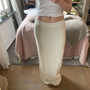Vit långkjol från A-DSGN - Jätte fin vit långkjol från A-DSGN med stretch i midjan. 100% bomull och fint skick, knappt använd. En pytteliten fläck bak på kjolen (se bild 5) 
