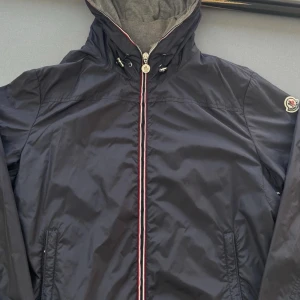  Moncler jacka | fet | bytes - Snygg mörkblå vindjacka från Moncler med huva och dragkedja framtill. Som är använd max 5ggr , byter gärna den mot andra kläder , skor , kepsar  snycken