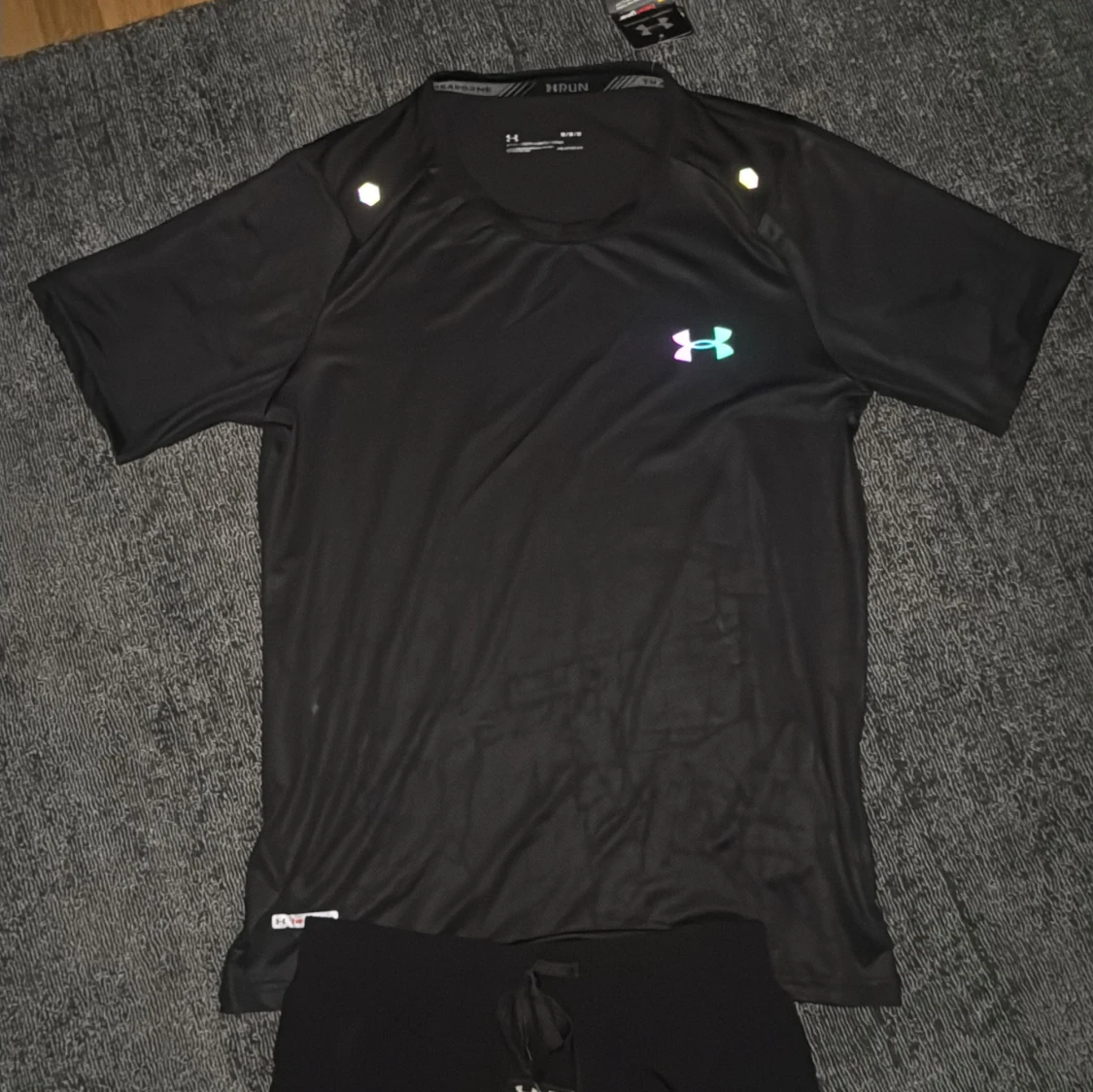 Svart t-shirt från Under Armour med regnbågsdetaljer