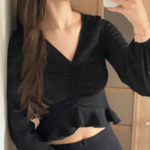 Svart volangtopp - V-ringad svart topp med volanger.