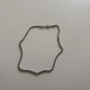 Silverfärgat kedjehalsband - Säljer ett stilrent pansarhalsband från guldfynd. Perfekt för dig som gillar enkla men snygga accessoarer. Halsbandet är av äkta 925 silver. 45cm långt och 4mm brett. 