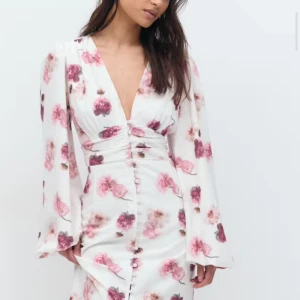 Vit blommig klänning med knappar - Säljer en denna populära ginatricot klänningen. Slutsåld överallt. Aldrig använd, prislapp kvar. 💗