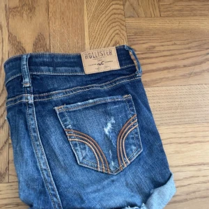 Mörkblå jeansshorts från Hollister - Snygga mörkblå jeansshorts från Hollister med slitna detaljer