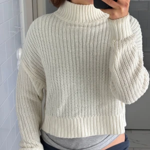 Vit croppad stickad polotröja från H&M - Säljer en vit croppad stickad polotröja från H&M. Tröjan har hög krage, lång ärm och ett grovt stickat mönster. Perfekt för lager-på-lager och ger en trendig look. Fin till en sommarkväll! ☀️Köparen står för frakt. Det är bara att skriva för fler bilder. 