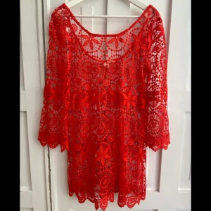 Röd strand klänning från H&M Coachella - Säljer en röd strand klänning från H&M Coachella-kollektionen. Blusen är i genombruten spets med blommigt mönster och har trekvartsärm 💃🏽