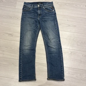 Blå jeansbyxor från Replay - Säljer ett par klassiska blå jeans från Replay med raka ben och normal passform. Jeansen har fem fickor, dragkedja och knapp i gylfen samt Replay-logga på bakfickan och läderpatch bak i midjan. Passar dig som är 150-160 cm. Nypris 800kr bästa skicket priset kan diskuteras! Modell Thad