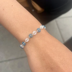 Pärlarmband med blå och vita blommor - Superfint armband med små blommor gjorda av blå och vita pärlor. 